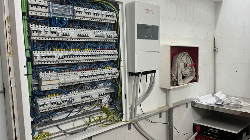Cuadro eléctrico junto al inversor híbrido y la batería de litio de una instalación de autoconsumo