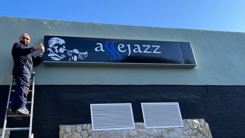 Rejillas de ventilación y rótulo luminoso colocados en la fachada de un local de hostelería en Sevilla